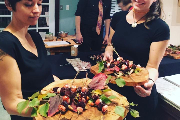 a group of people standing around a table with food