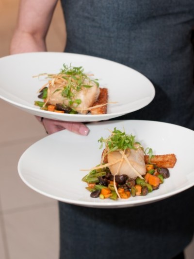 a woman sitting at a table with a plate of food