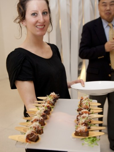 a group of people standing in front of a cake