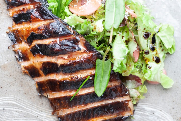 a slice of pizza sitting on top of a wooden cutting board