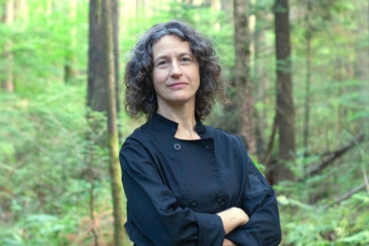 a woman standing in front of a forest