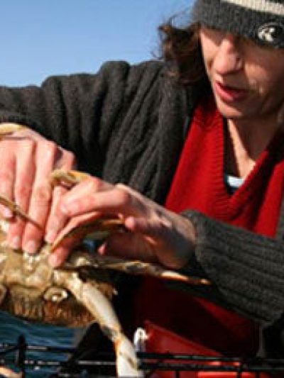 a person riding on the back of a crab on a body of water