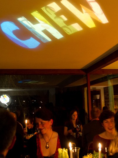 a group of people standing in front of a birthday cake with lit candles