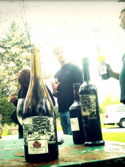 a person standing next to a bottle of wine