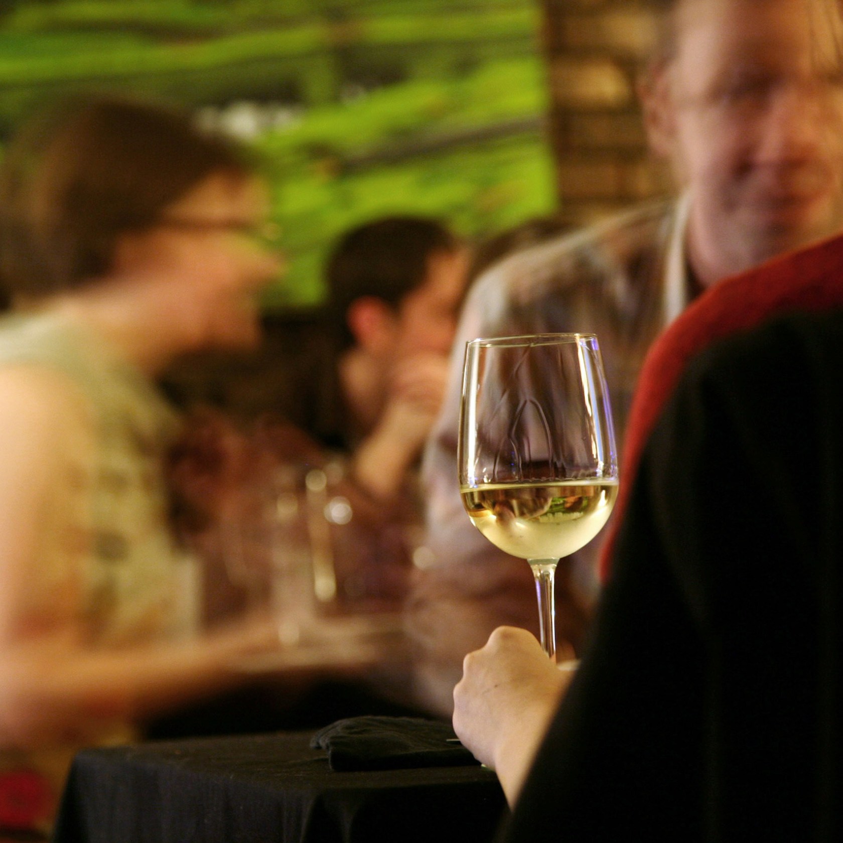 a person sitting at a table with wine glasses