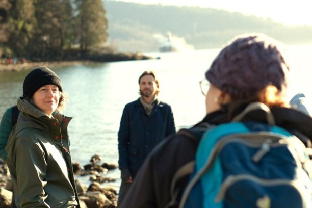 a group of people standing next to a body of water