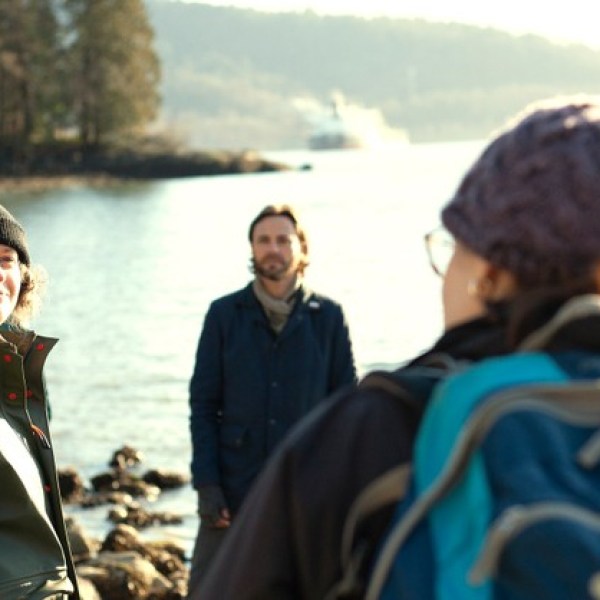 a group of people standing next to a body of water